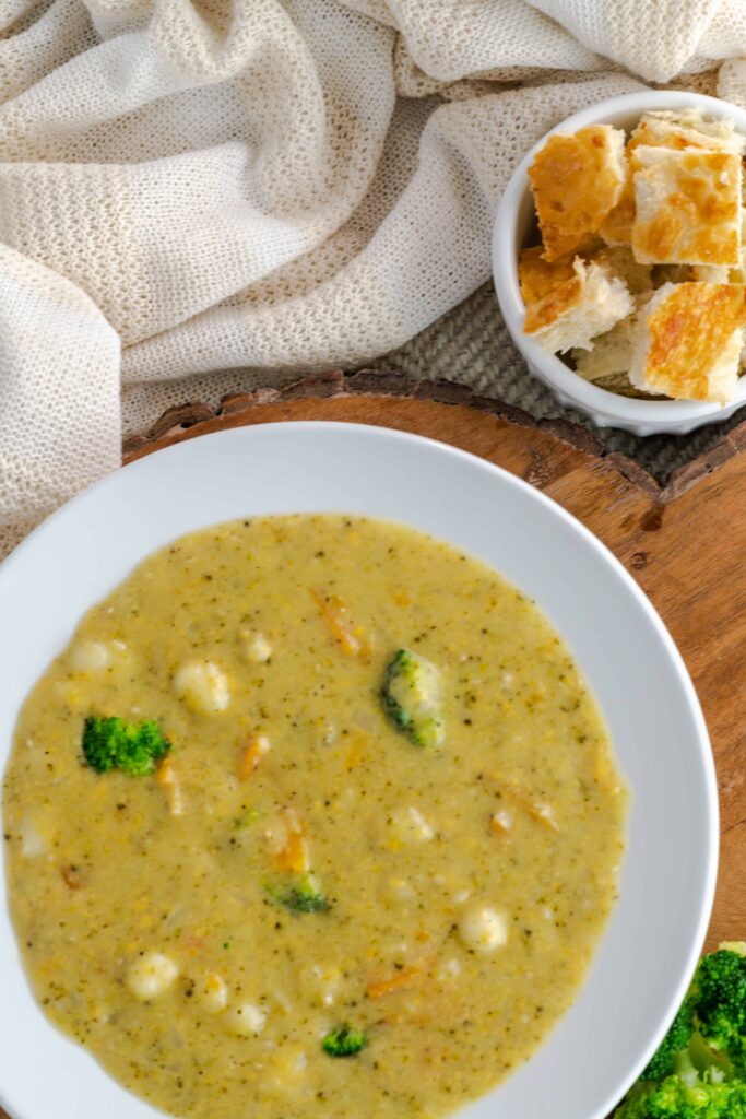 Instant Pot Broccoli Cheddar Gnocchi Soup with a side of bread pieces. 