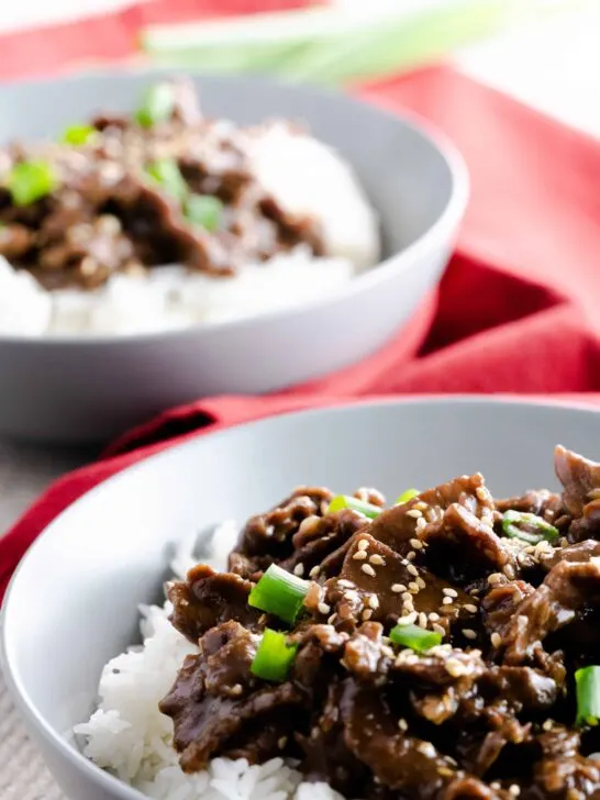 Two bowls of Instant Pot Garlic Sesame Beef & Rice with a red napkin.