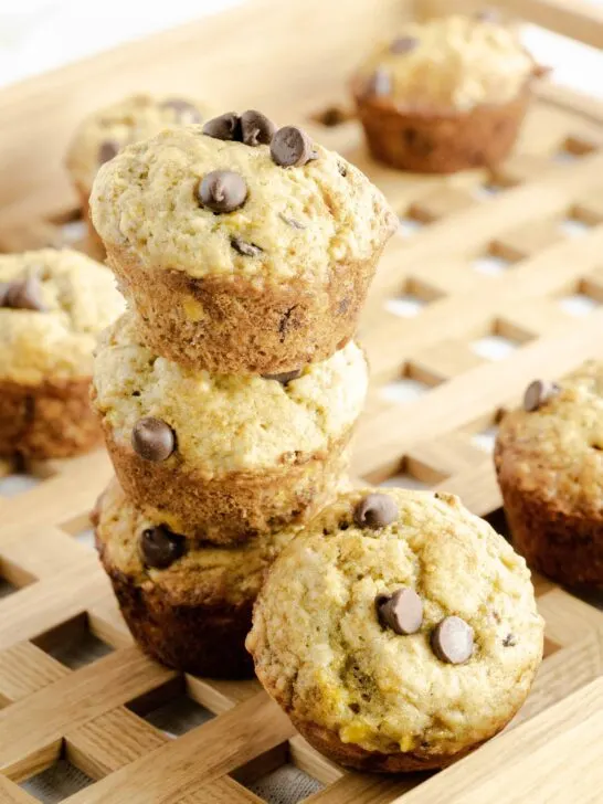 Banana Chocolate Chip Muffins stacked on a decorative wooden tray.