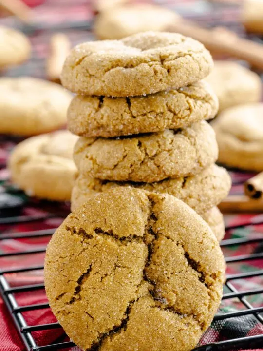 Chewy gingersnap cookies on a black wire rack.