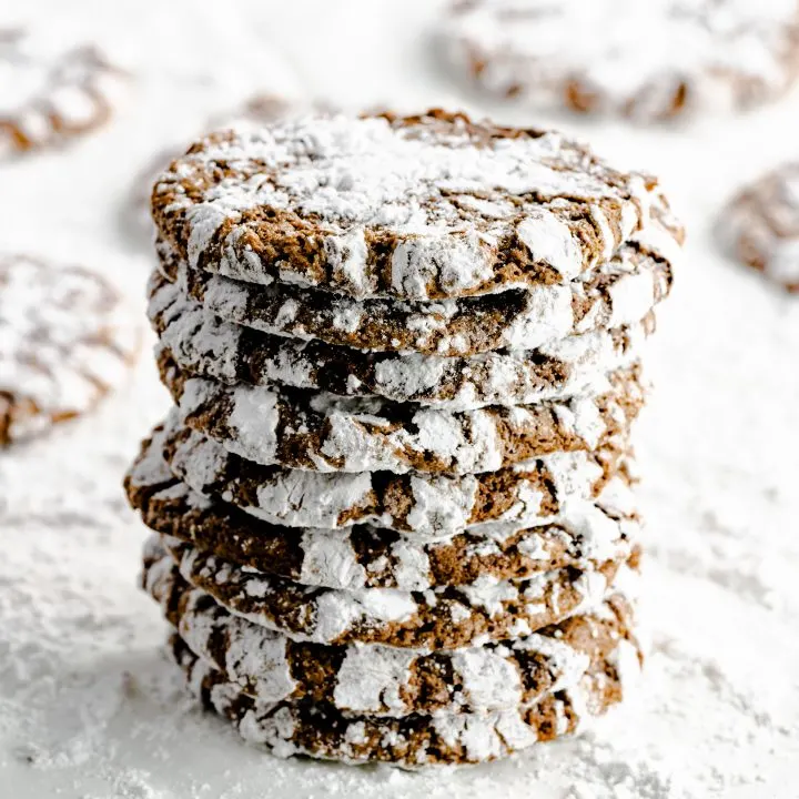 Nine chocolate cookies stacked and dusted with powdered sugar.