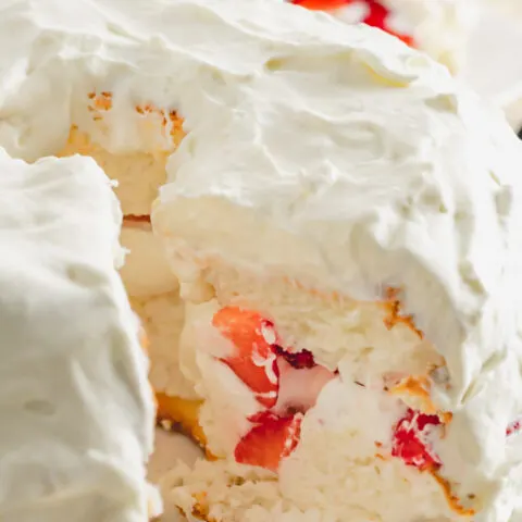 Layered angel food cake with strawberry and whipped cream filling.