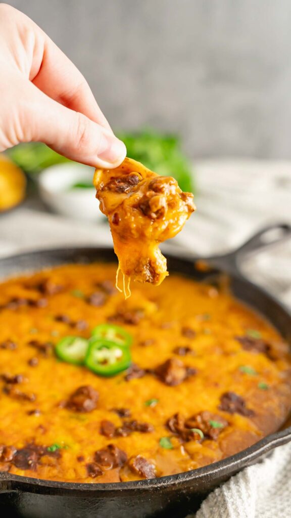A Frito scoop filled with cheesy chili dip with jalapenos.