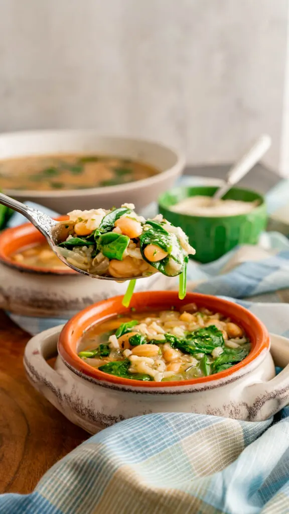 A heaping spoonful of Instant Pot White Bean Soup with spinach.