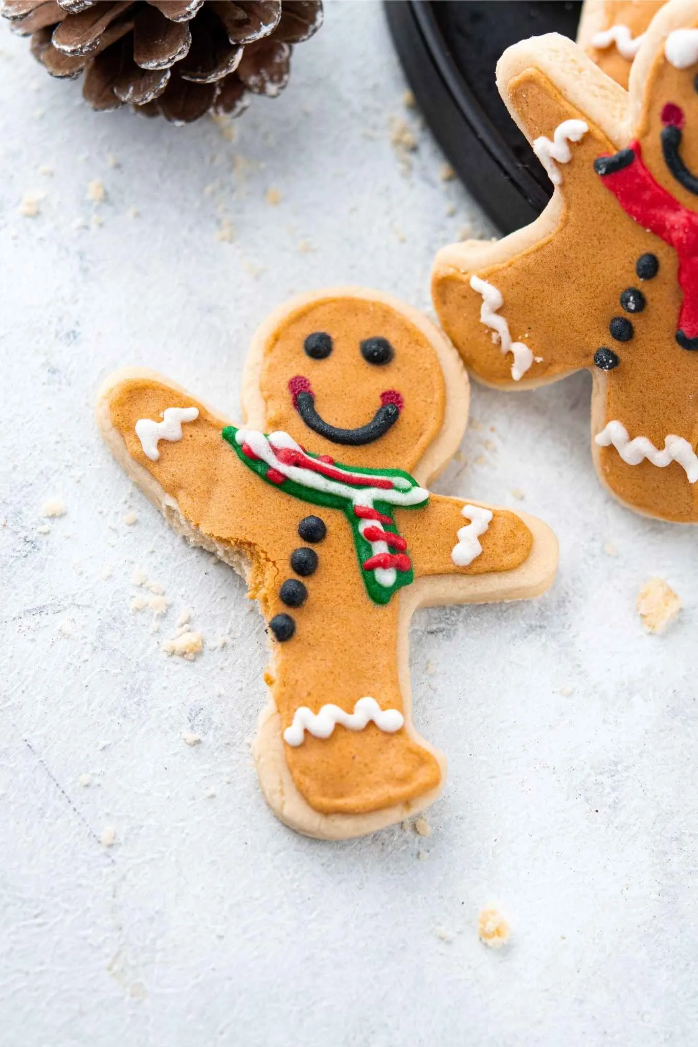 A gingerbread man Christmas sugar cookie with the leg bitten off.